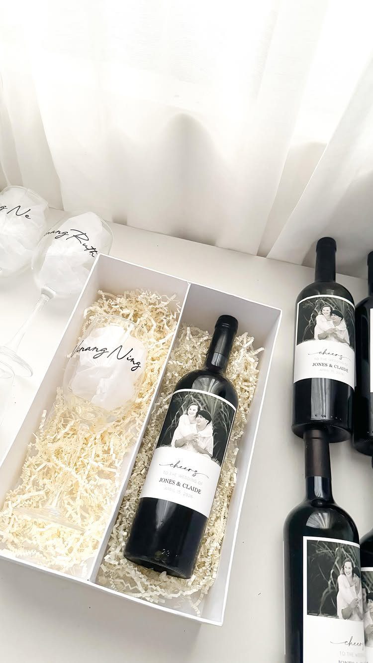 Custom wine bottles with photo labels in a white gift box with shredding.