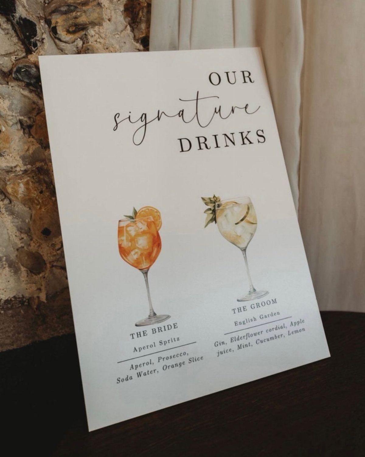 Signature drinks sign featuring illustrations of a bride and groom's cocktails.