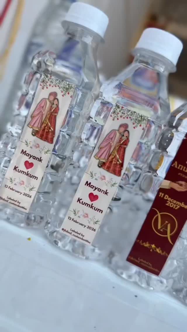 Customized water bottles with wedding labels featuring a couple's illustration and names.