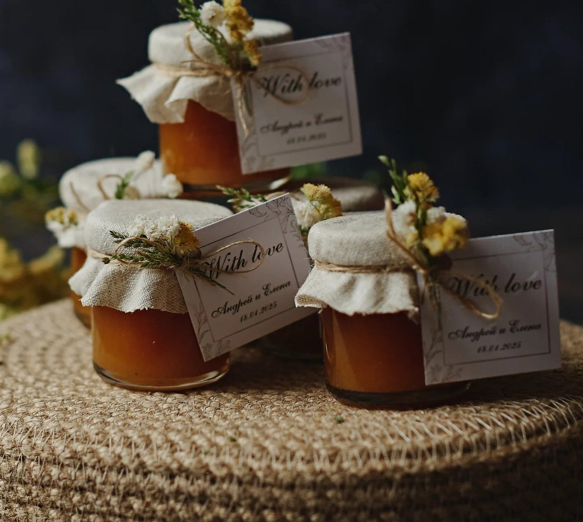 Small jars of orange jam with fabric lids and personalized gift tags.