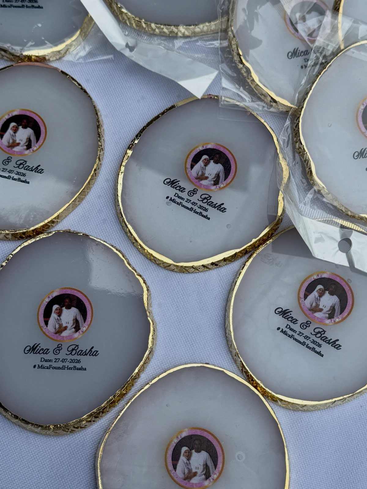 White agate coasters with gold edges featuring a couple's photo and wedding names.
