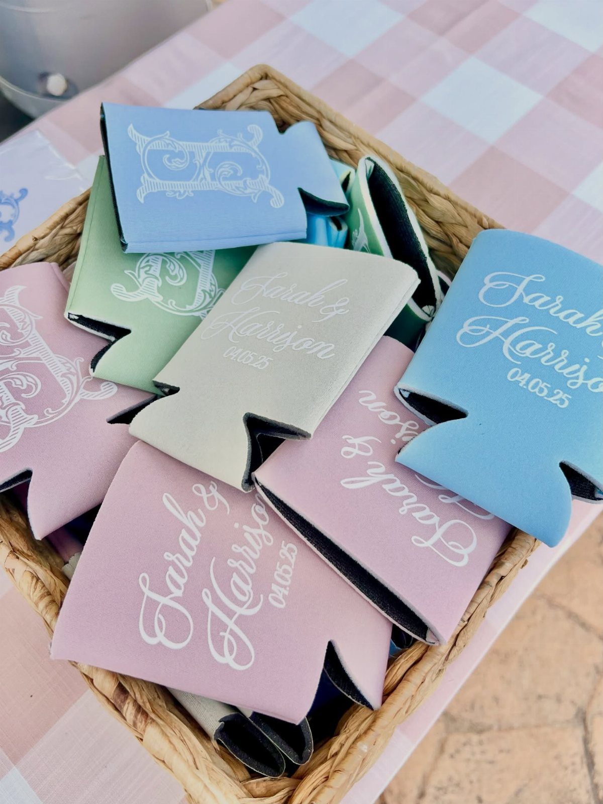 Personalized foam beverage koozies in pastel colors inside a woven wicker basket.