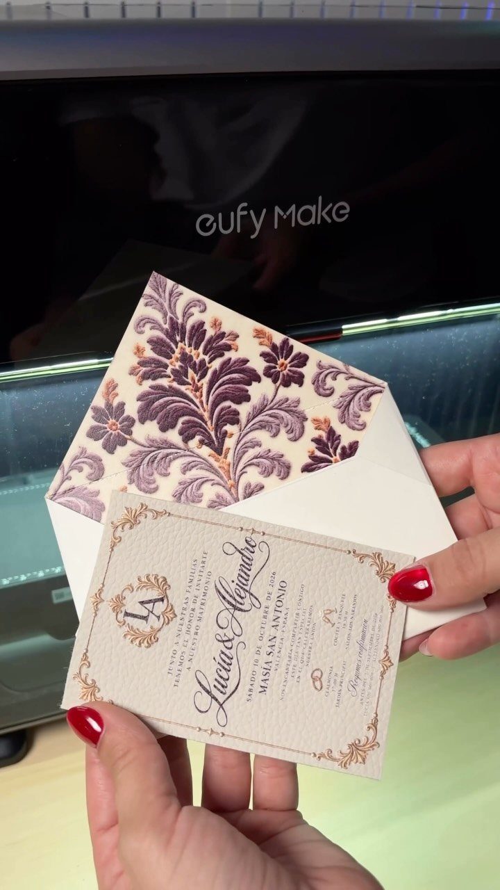Wedding invitation card with gold borders and a purple floral lined envelope.