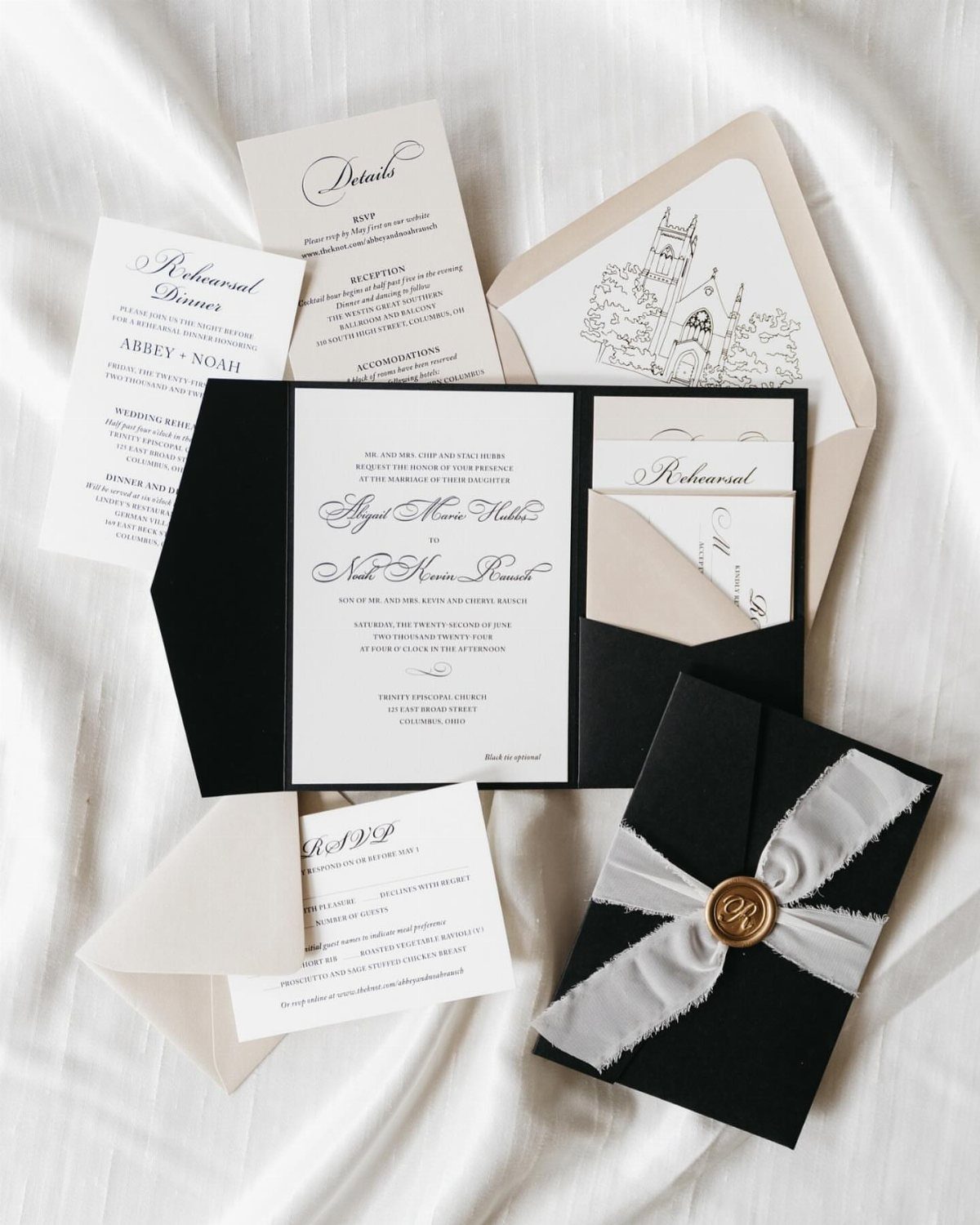 Black and white wedding invitation suite featuring a pocket folder and wax seal.