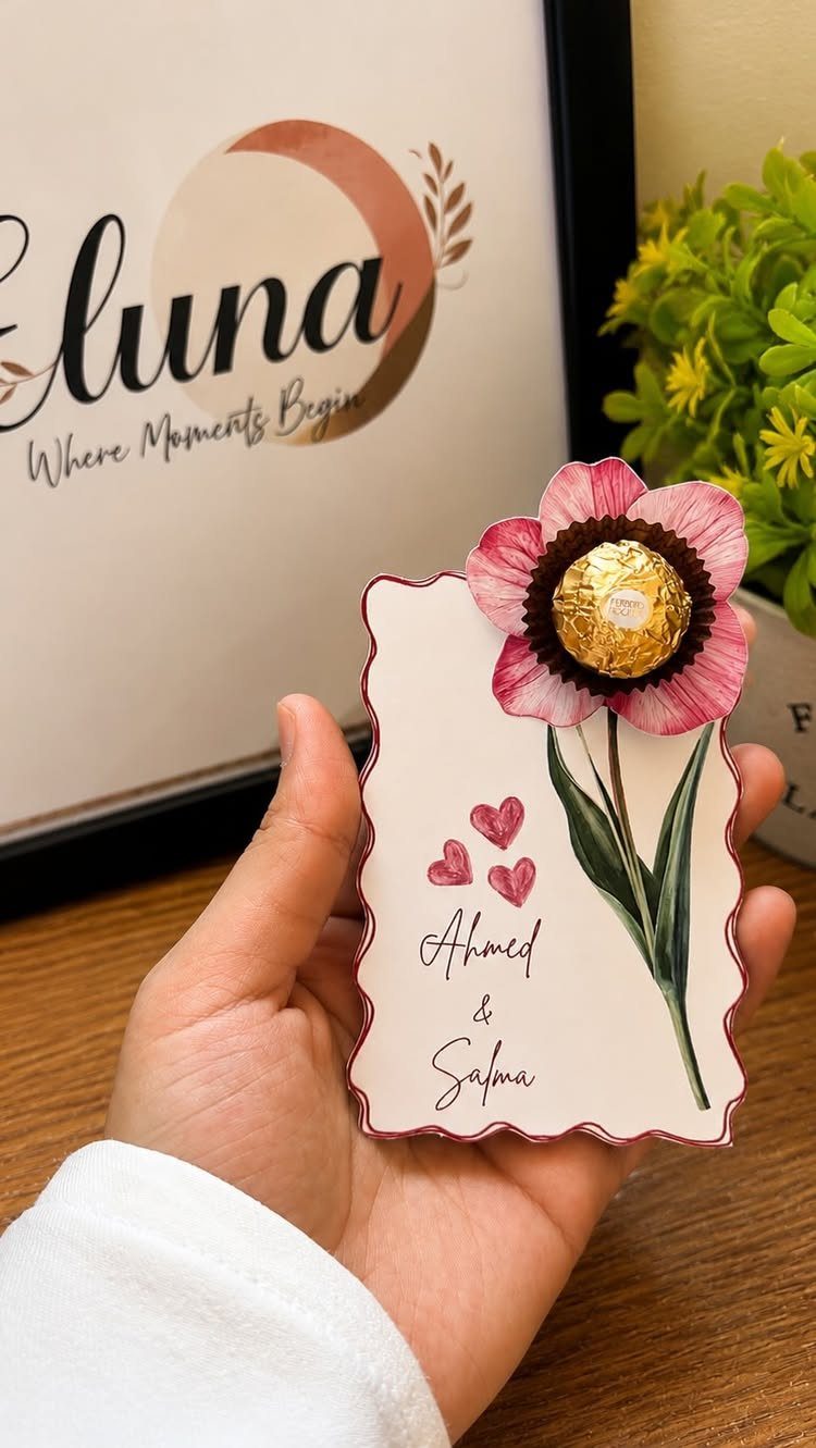 Wedding invitation card with 3D paper flower and gold chocolate held in hand