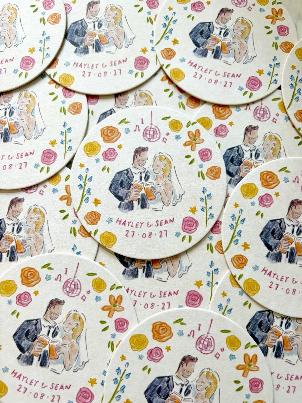 Circular white coasters with an illustration of a wedding couple and floral accents.