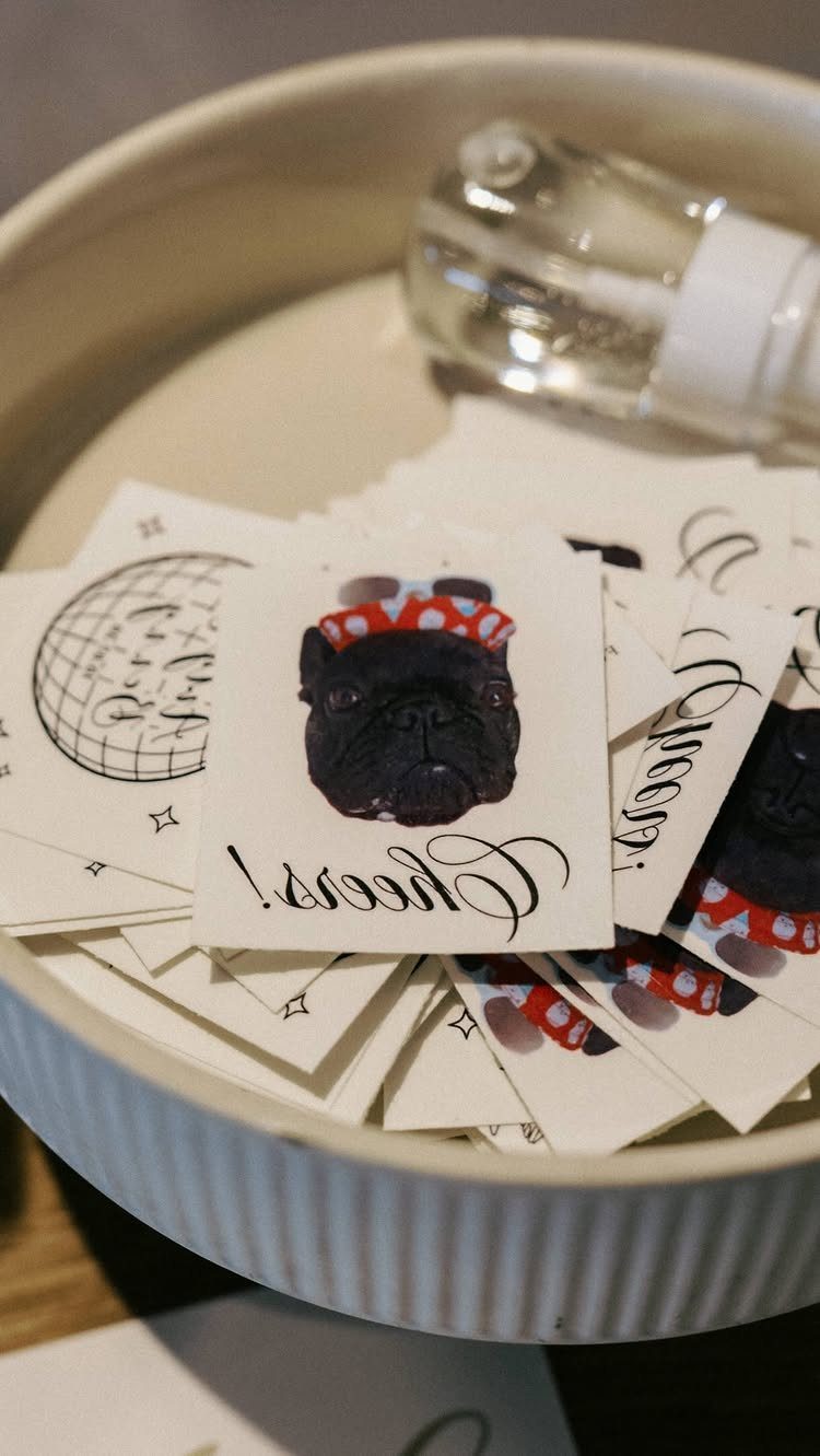 Temporary tattoos featuring a pug in a party hat inside a white bowl.