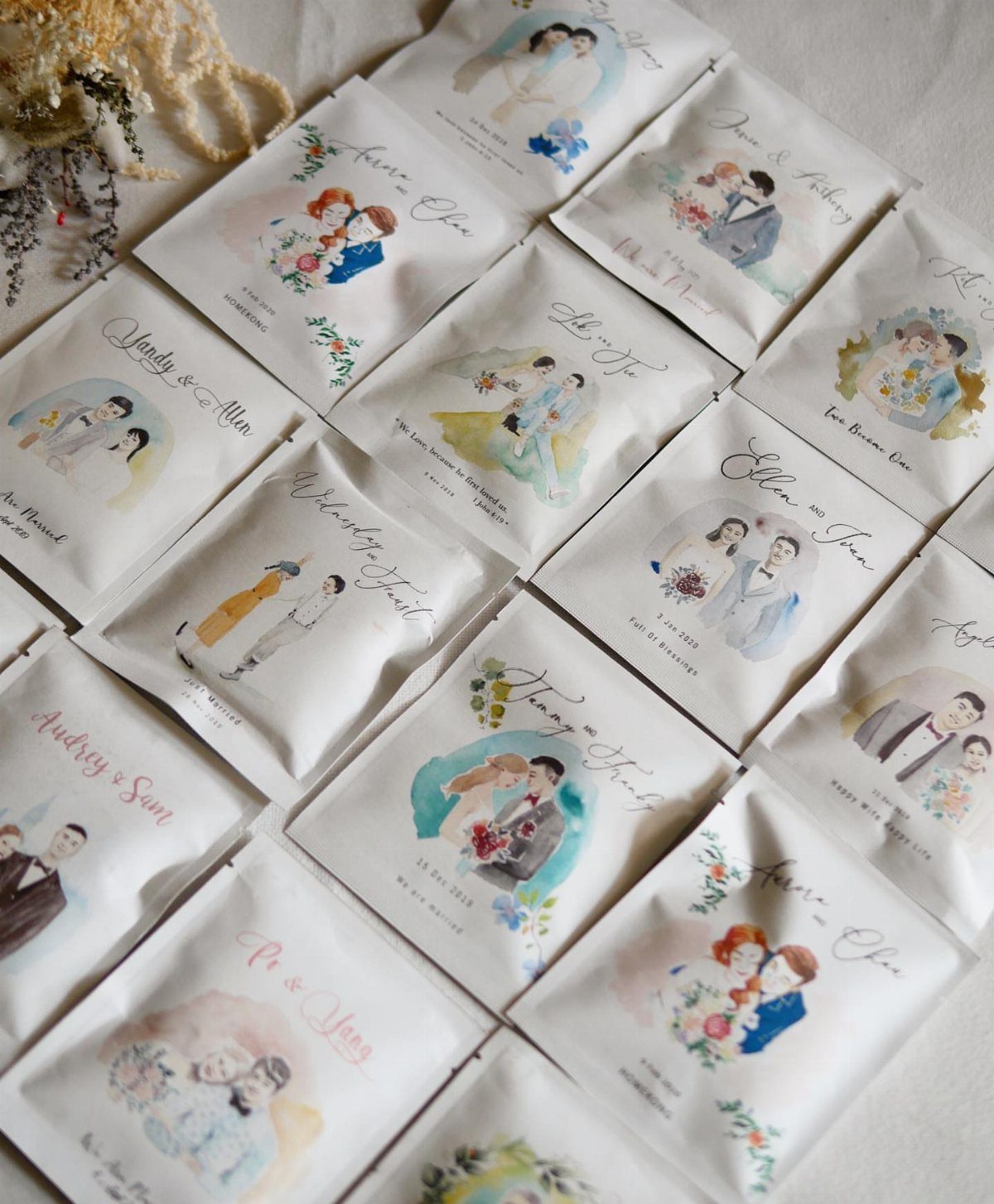 White tea bag sachets featuring watercolor illustrations of couples and personalized wedding text.