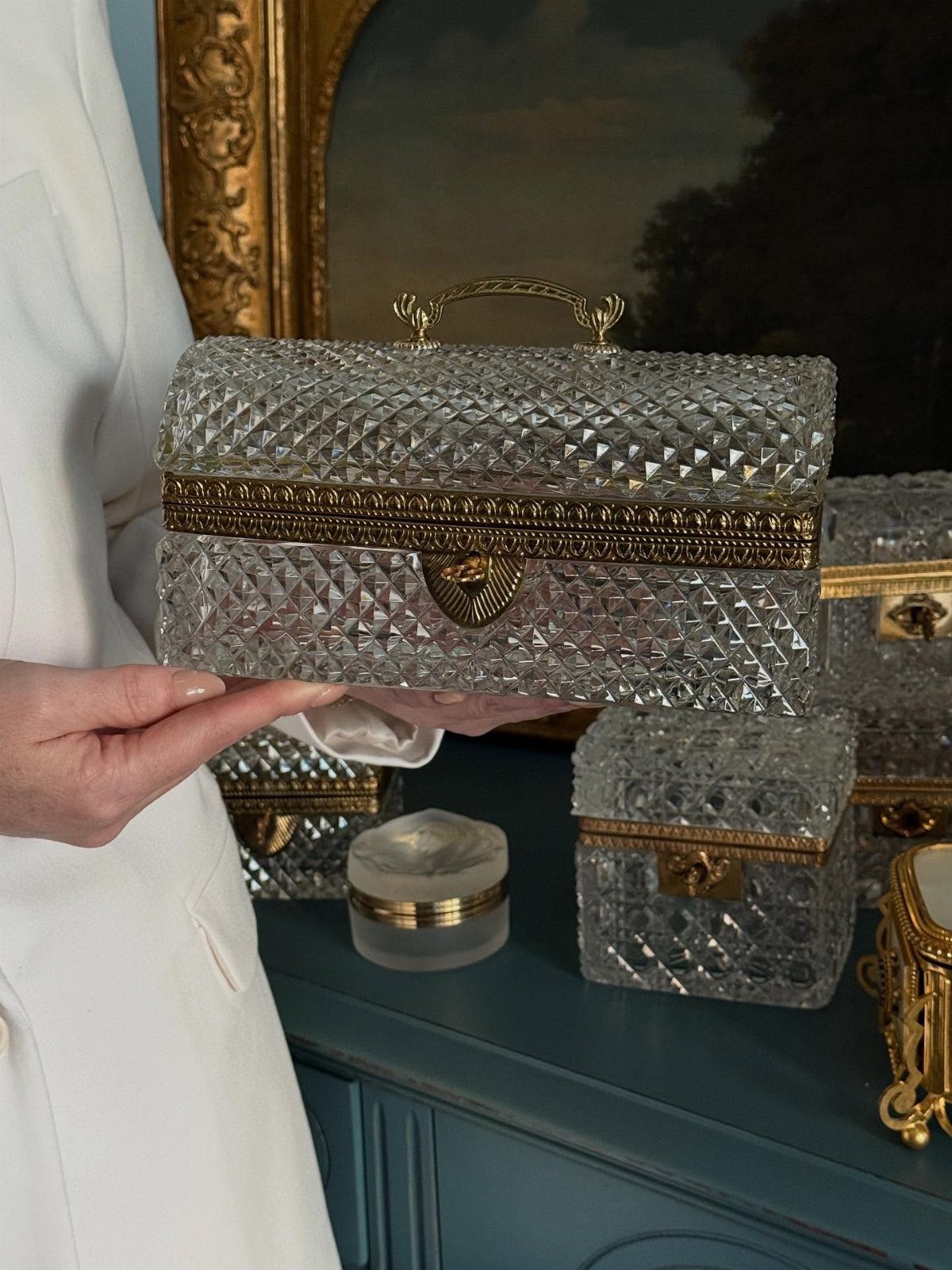 Textured clear glass trinket box with gold trim held by a person