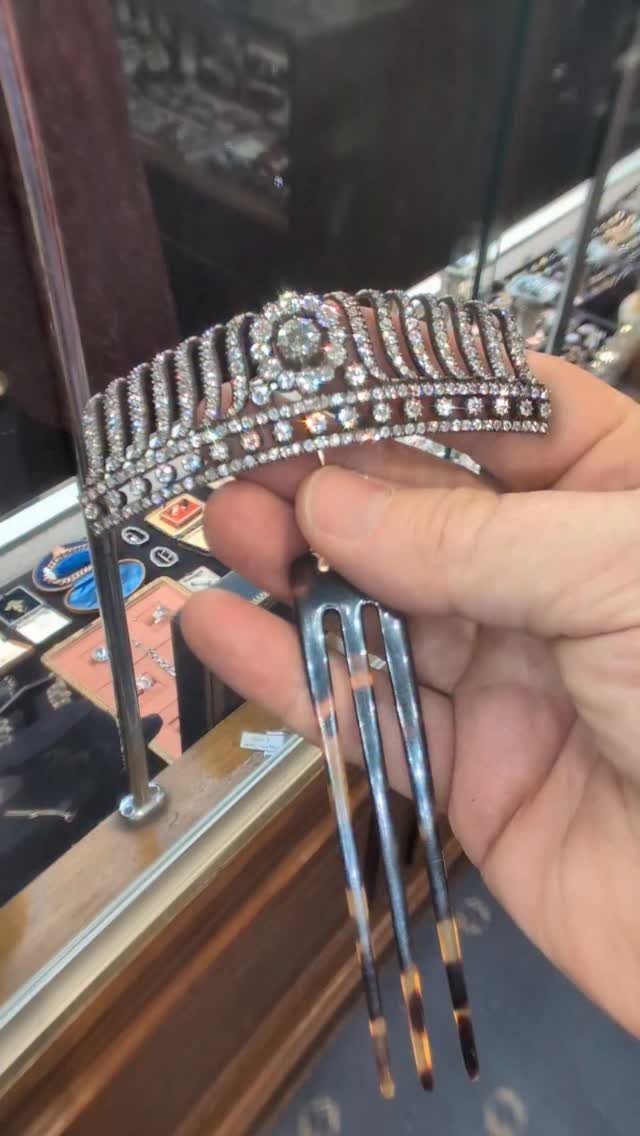 Rhinestone hair comb with tortoiseshell prongs held by a hand in a store.