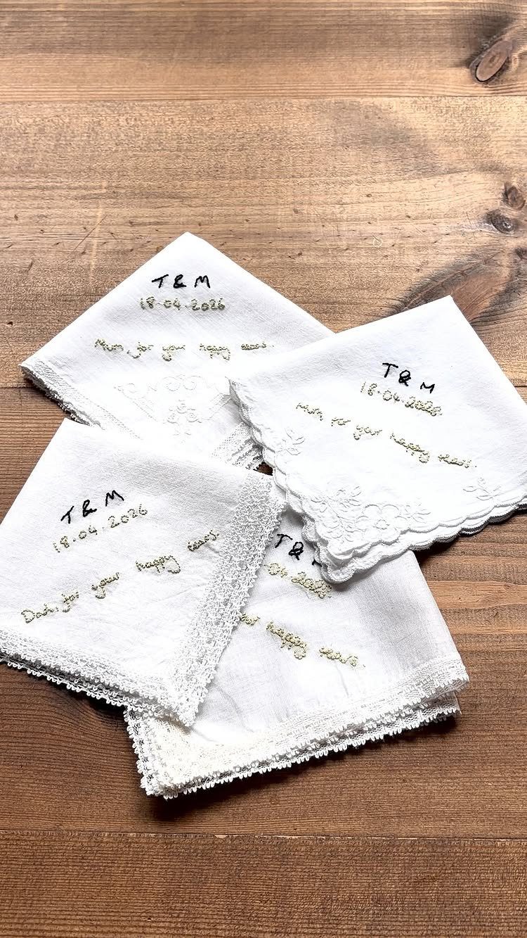 White linen handkerchiefs with lace edges and handwritten text on wooden background