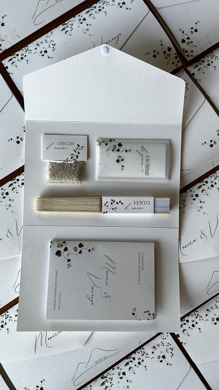 Wedding invitation suite with matching floral stationery and a wooden fan on envelopes.