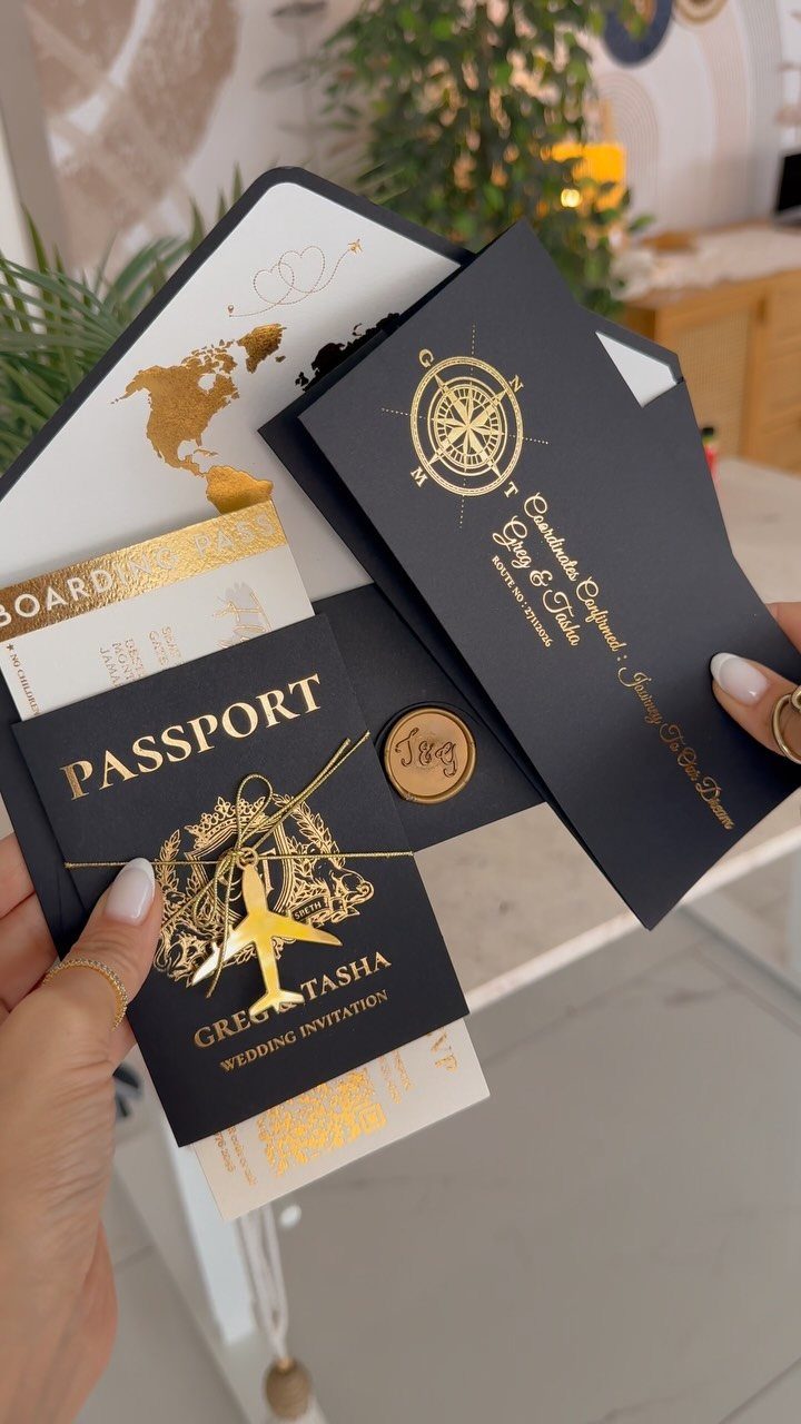 Travel-themed wedding invitation suite with passport, boarding pass, and gold compass details.