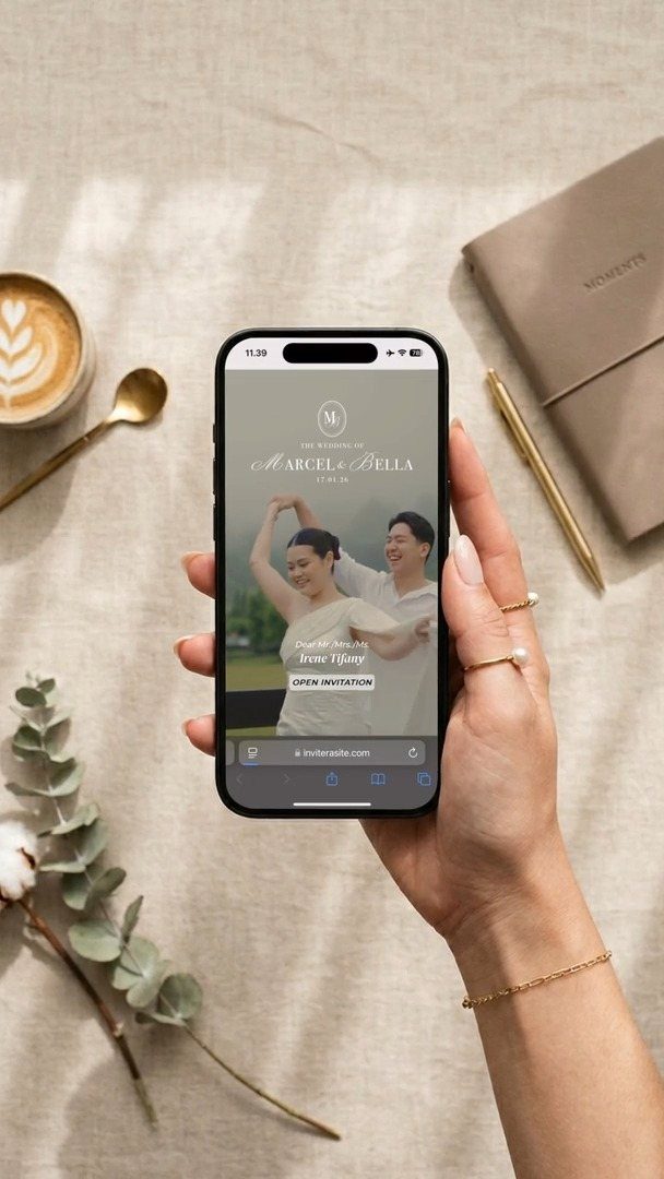 Smartphone displaying a digital wedding invitation for Marcel and Bella on a linen surface