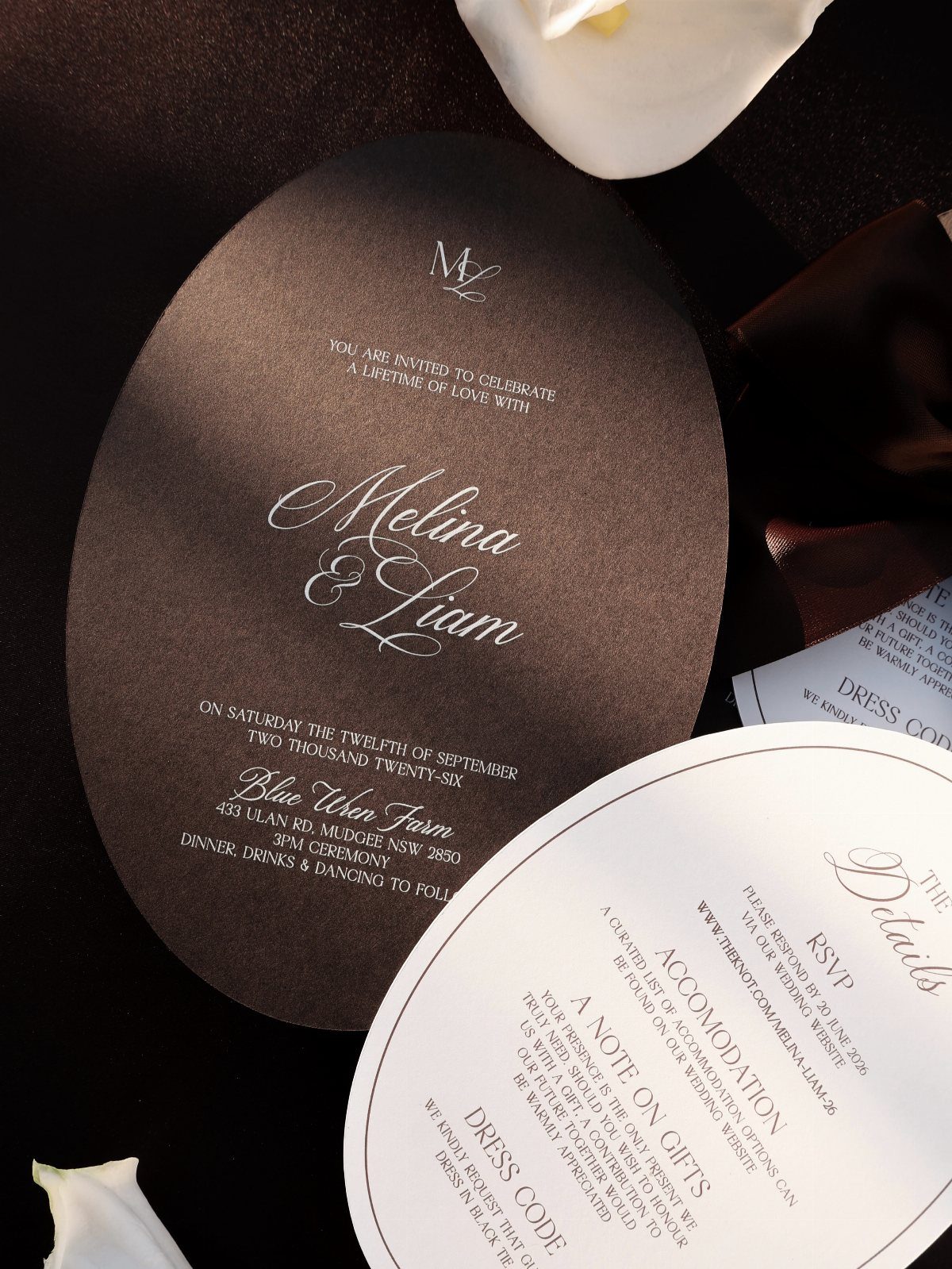 Oval wedding invitations in dark brown and white with elegant typography and layout.