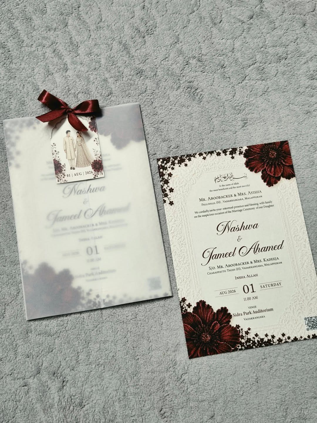 Wedding invitation suite with a small photo of a couple and burgundy floral accents.