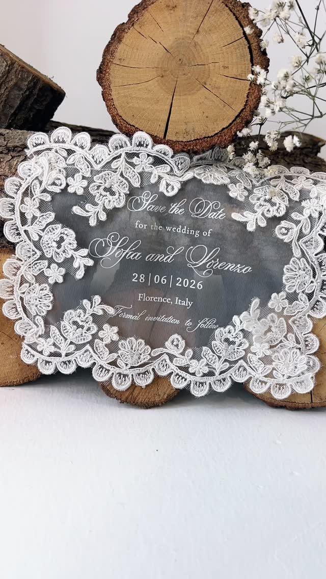 Acrylic wedding save-the-date card with white lace border on a rustic wooden log