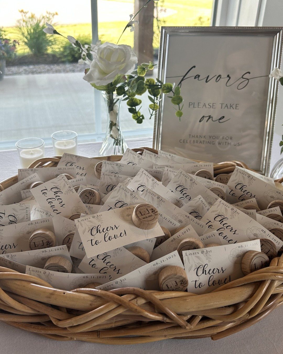 Wicker basket of wedding favors with corks and cards saying Cheers to love