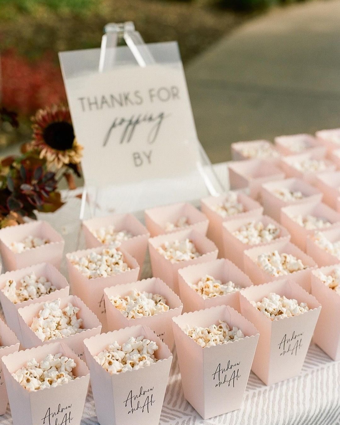 Popcorn favors in pink boxes with a Thanks for Popping By sign.