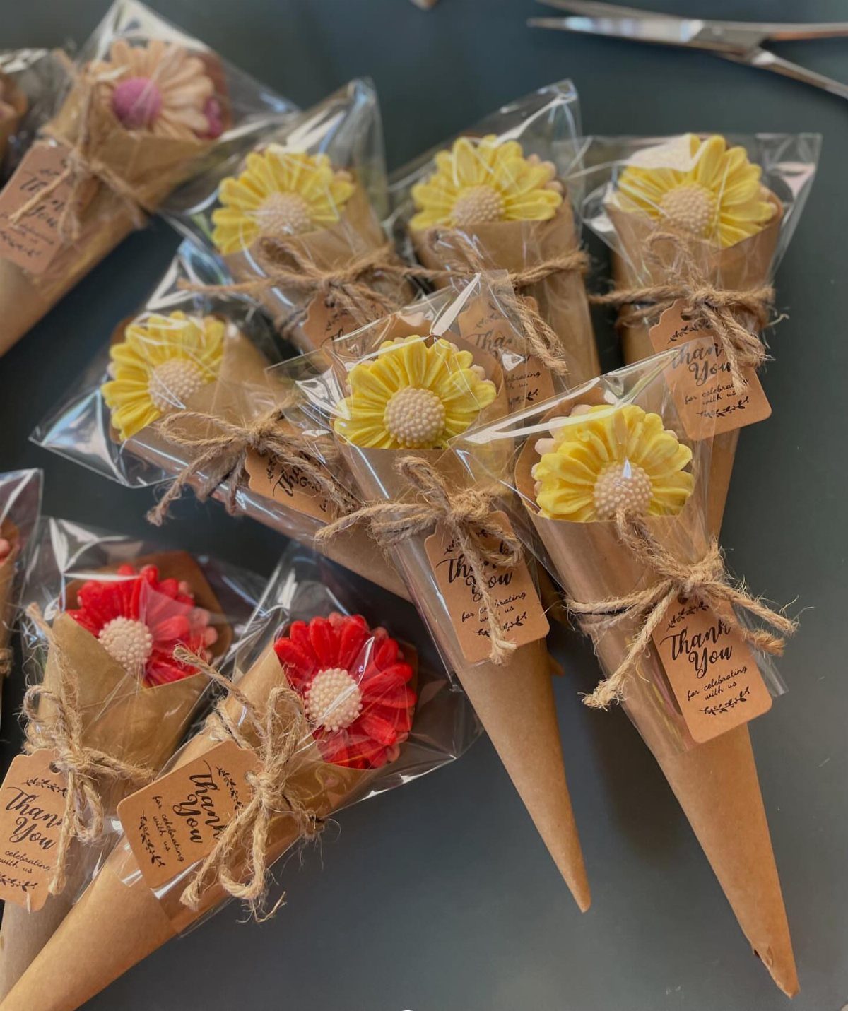Flower-shaped handmade soaps wrapped in brown paper cones with thank you tags
