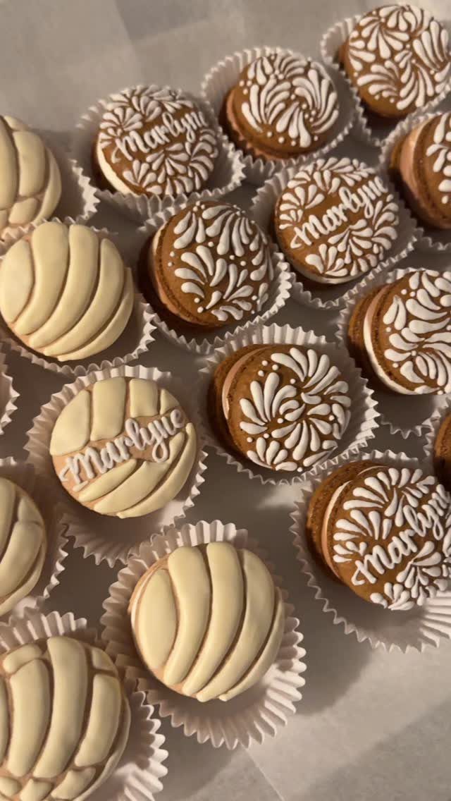 Round decorated cookies with white icing in paper liners on a white background.