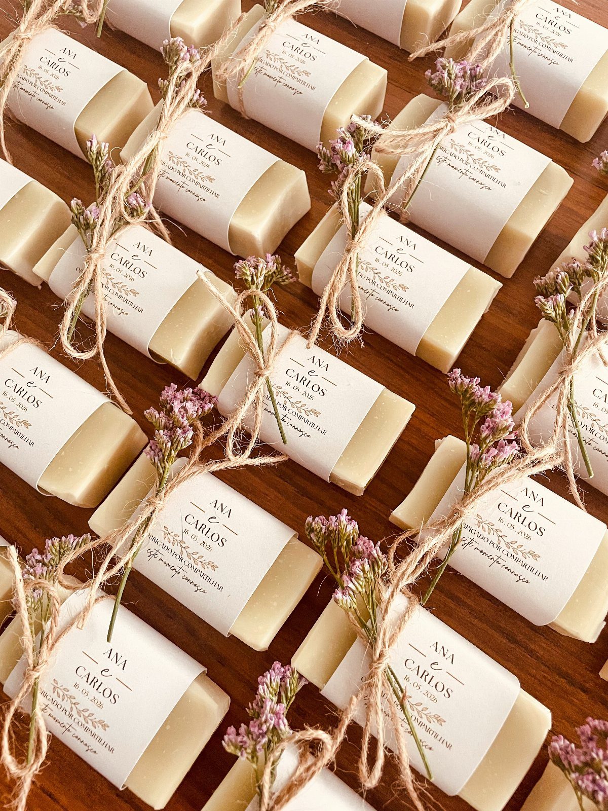 Cream-colored handmade soap bars wrapped in white labels with twine and dried flowers.