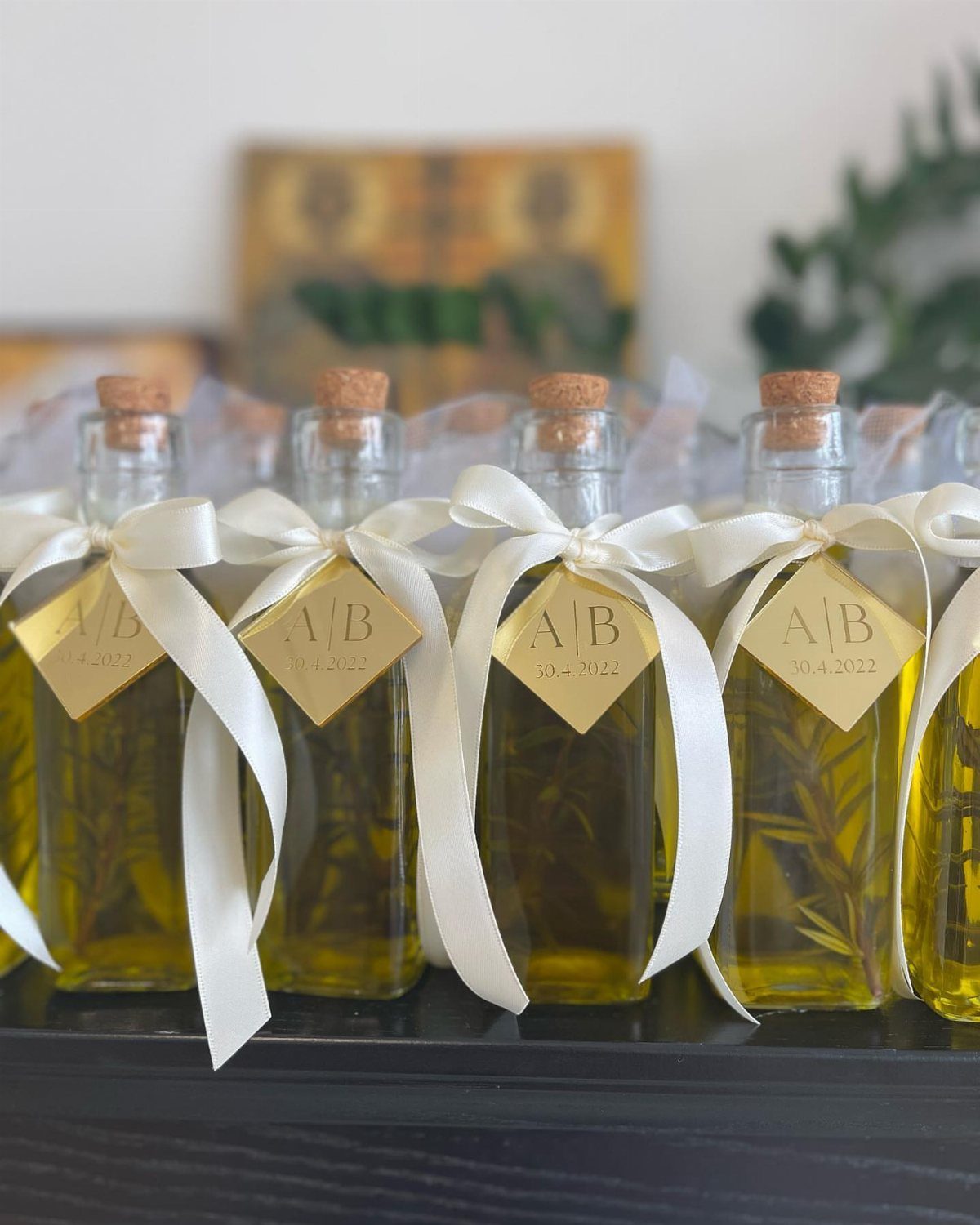 Small glass bottles of olive oil with white ribbons and gold tags.