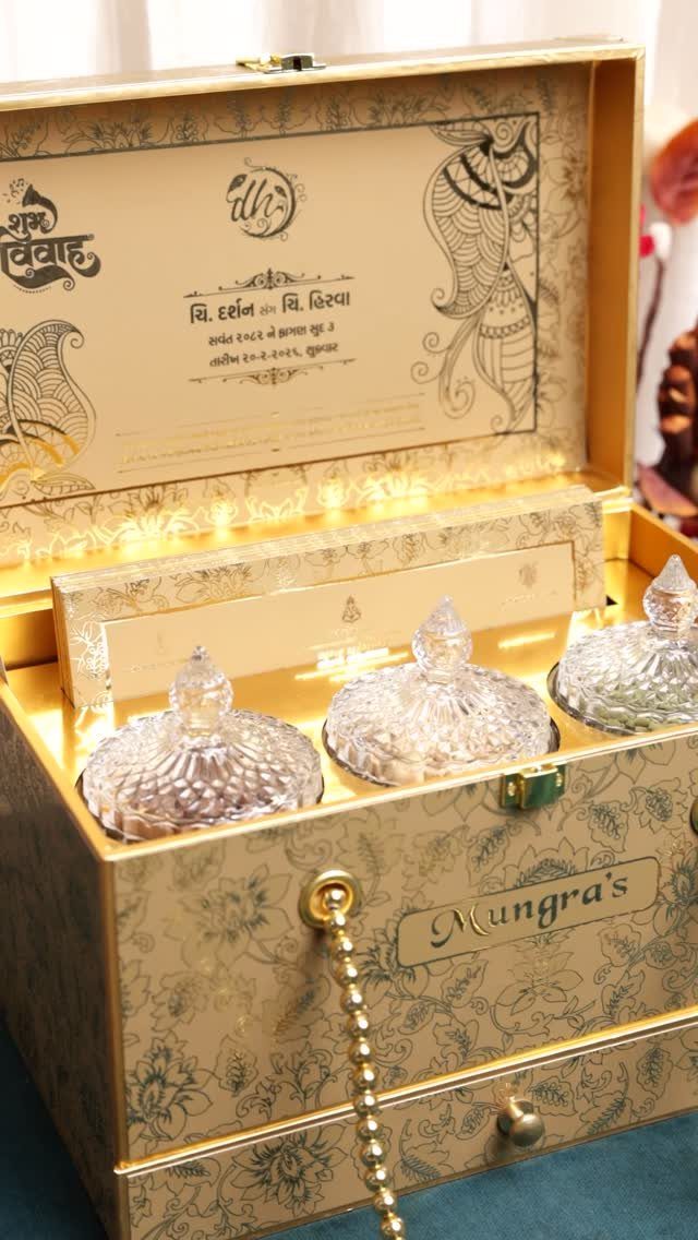 Ornate gold gift box containing three small decorative glass jars with fairy lights.