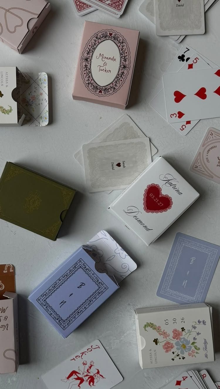 Decorative playing card boxes and scattered cards on a light grey background.