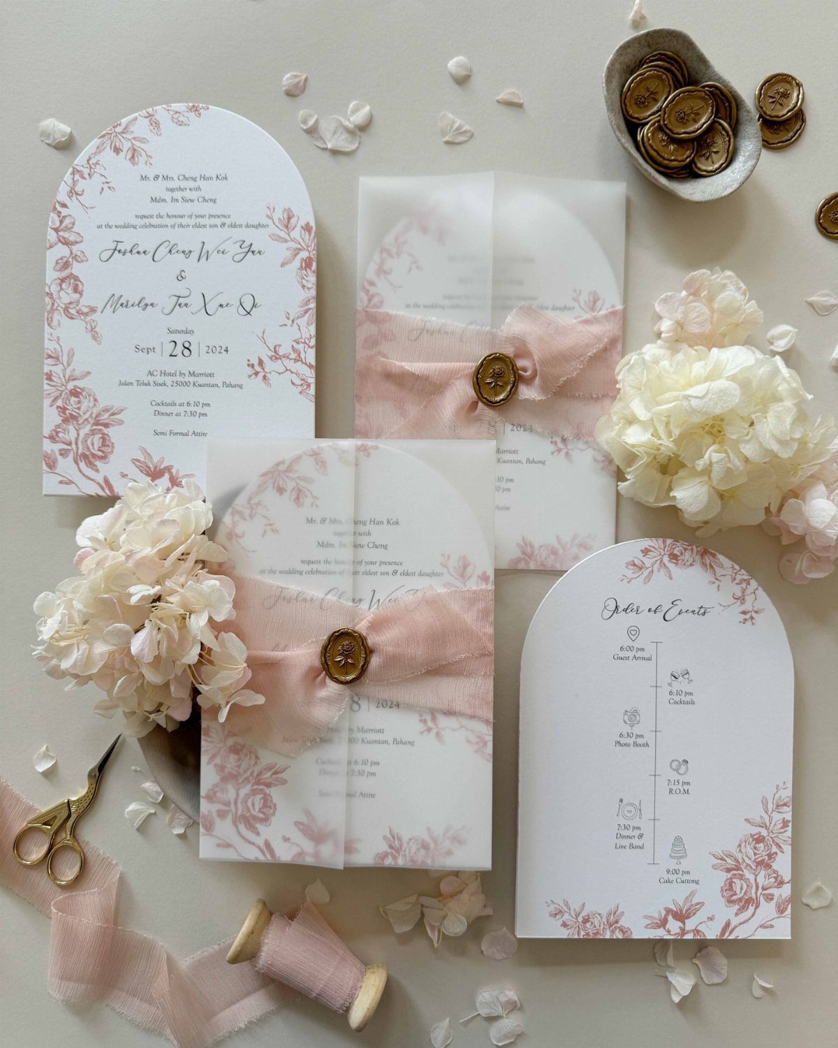 Arched wedding invitation cards with peach floral accents, ribbons, and white flowers.