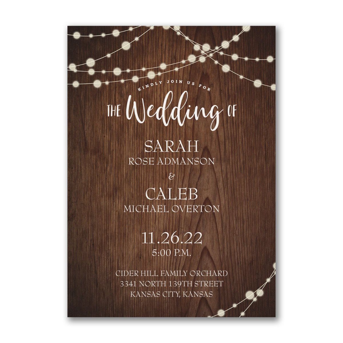 Wedding invitation with dark wood texture background and glowing string light accents.
