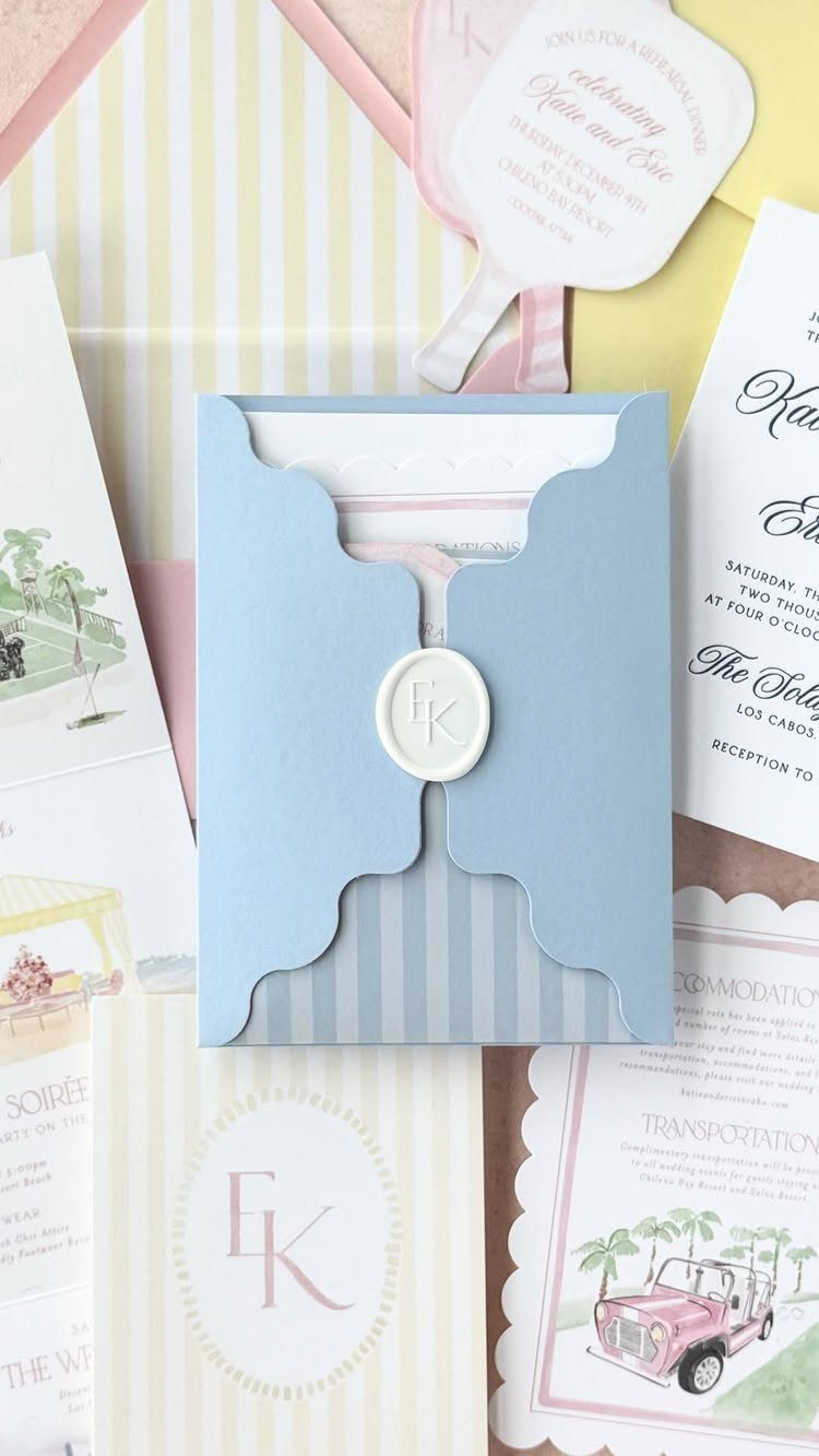 Wedding invitation suite with light blue scalloped envelope, wax seal, and striped cards.
