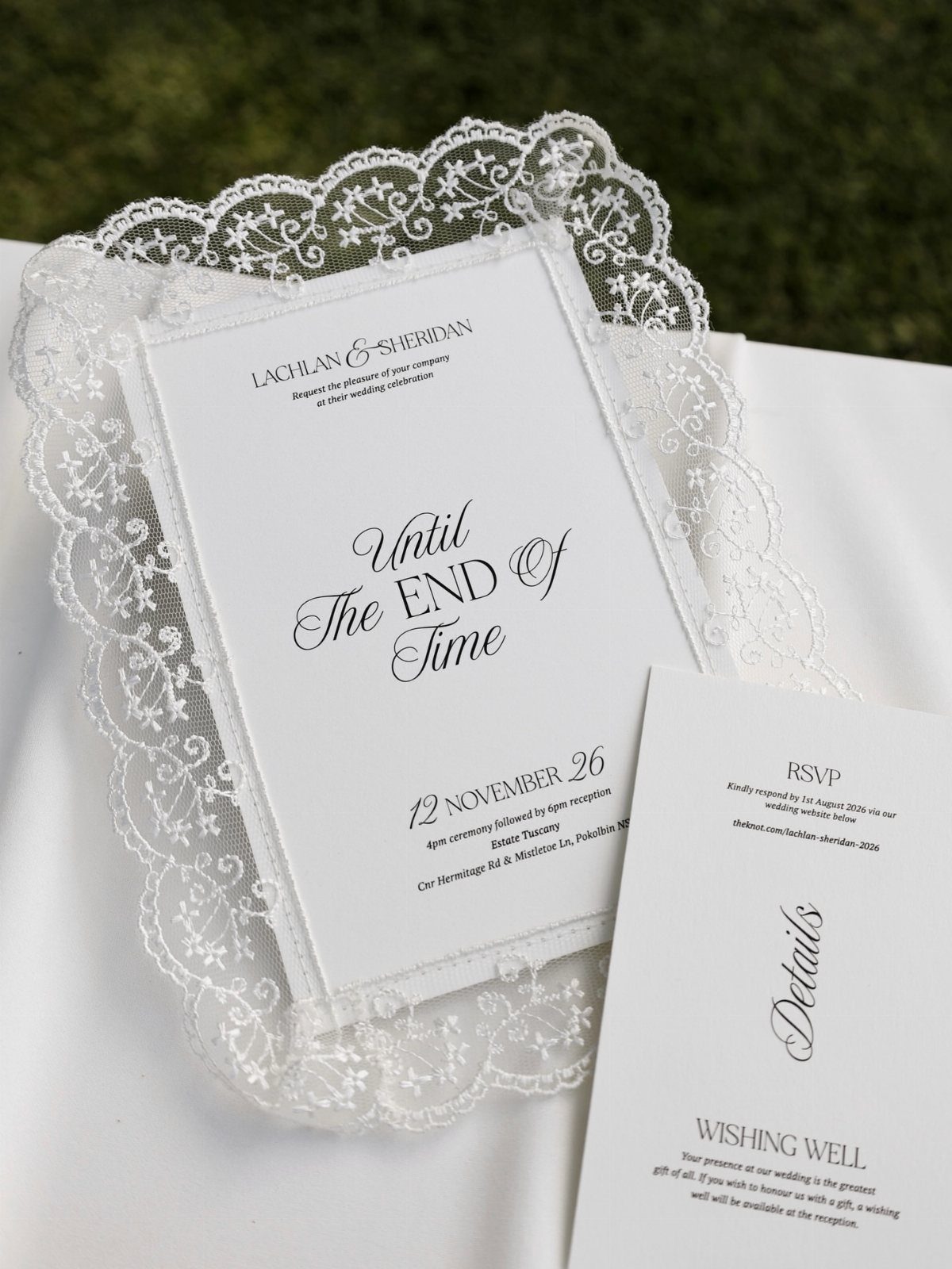 Wedding invitation card resting on a white lace doily with accompanying detail cards.