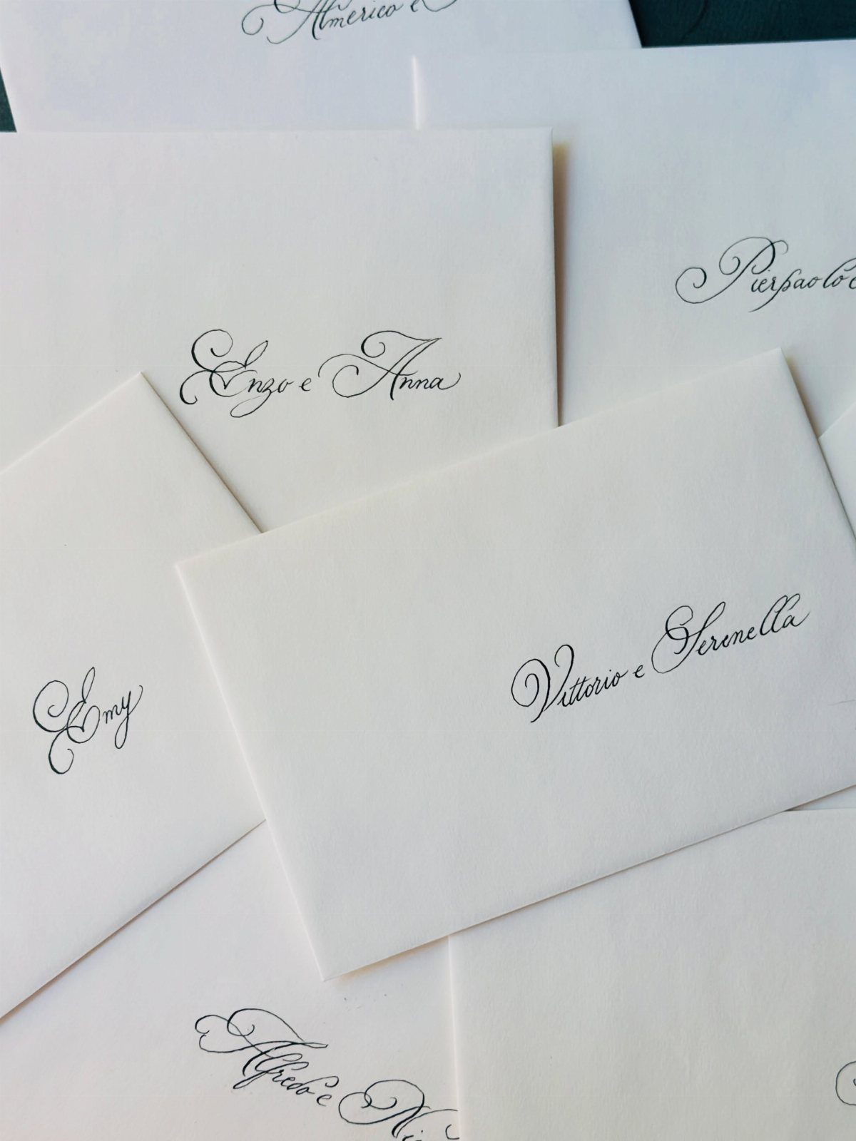 White envelopes with elegant black calligraphy names written in cursive script.