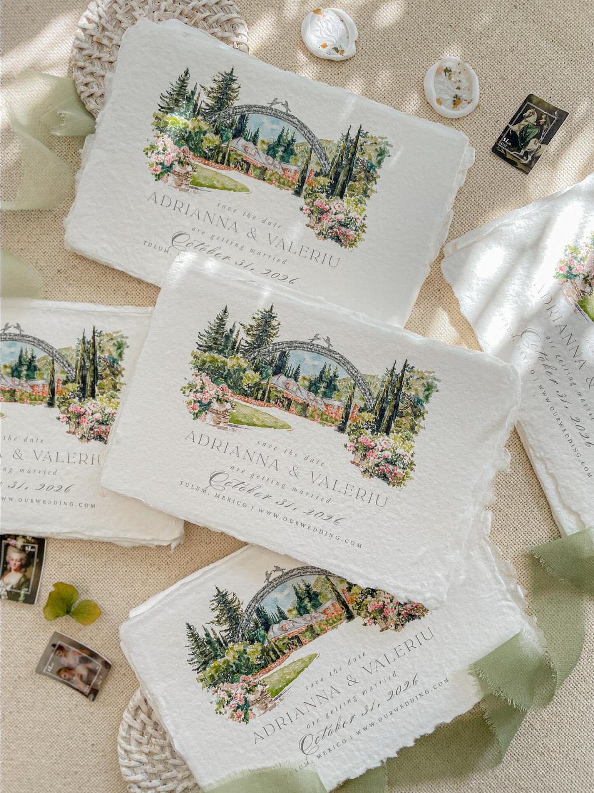 Deckle-edged save the date cards with watercolor landscape illustrations and gold calligraphy text.