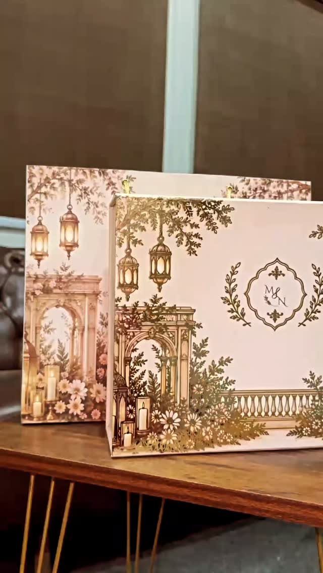 Wedding invitation cards with gold classical architecture and floral illustrations on wooden table