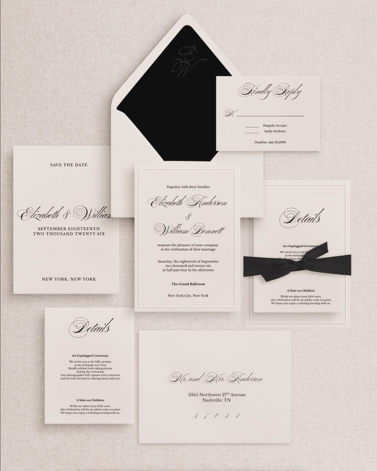 White wedding invitation suite with black typography and a black ribbon bow.