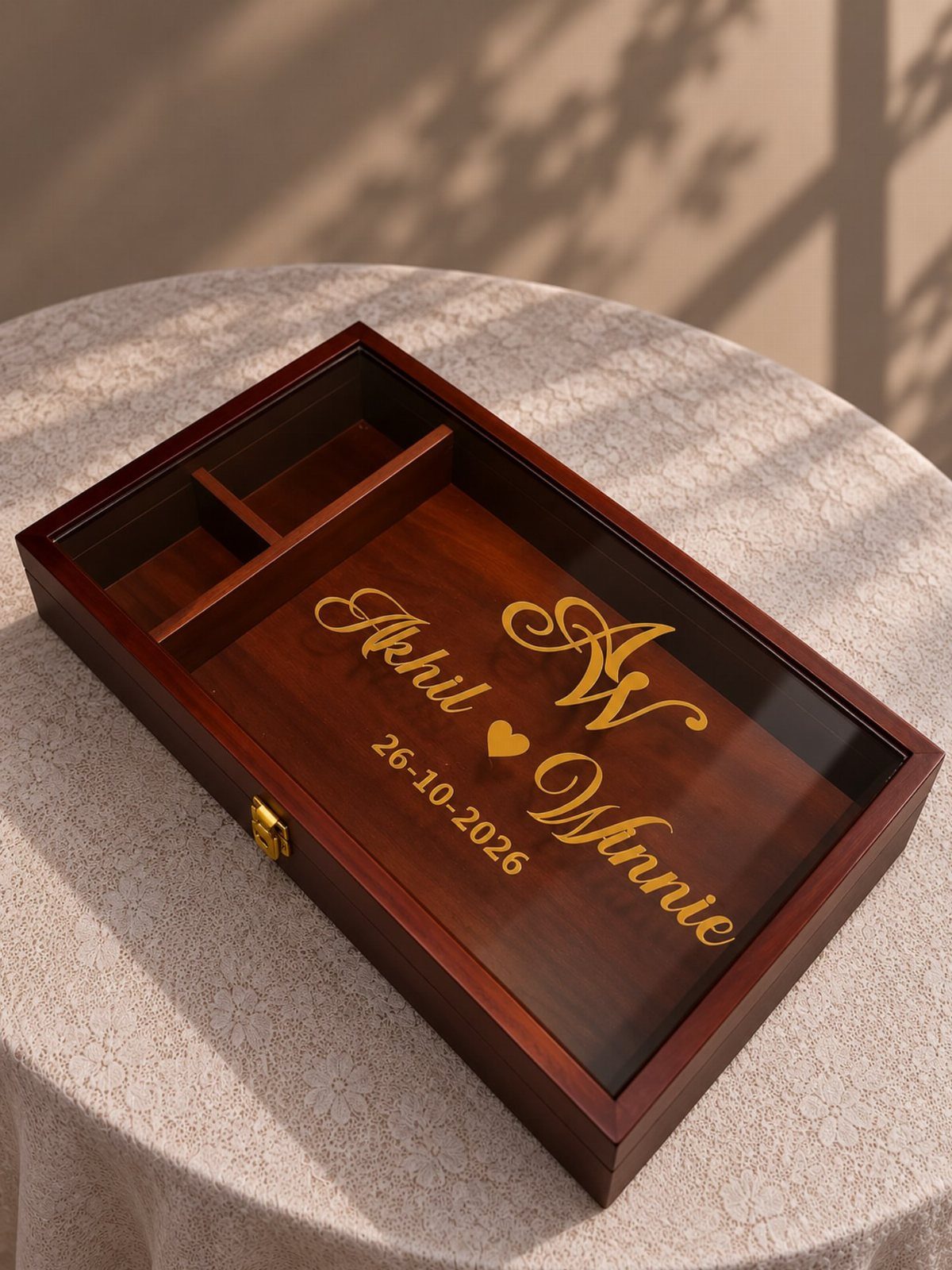 Wooden keepsake box with glass lid and gold engraved names and initials.