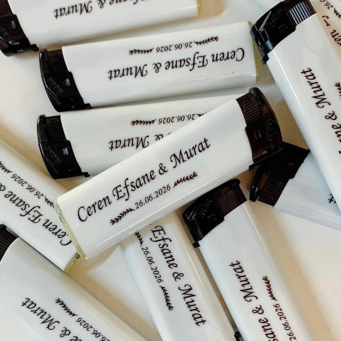 White Bic lighters printed with wedding names and date as personalized favors.