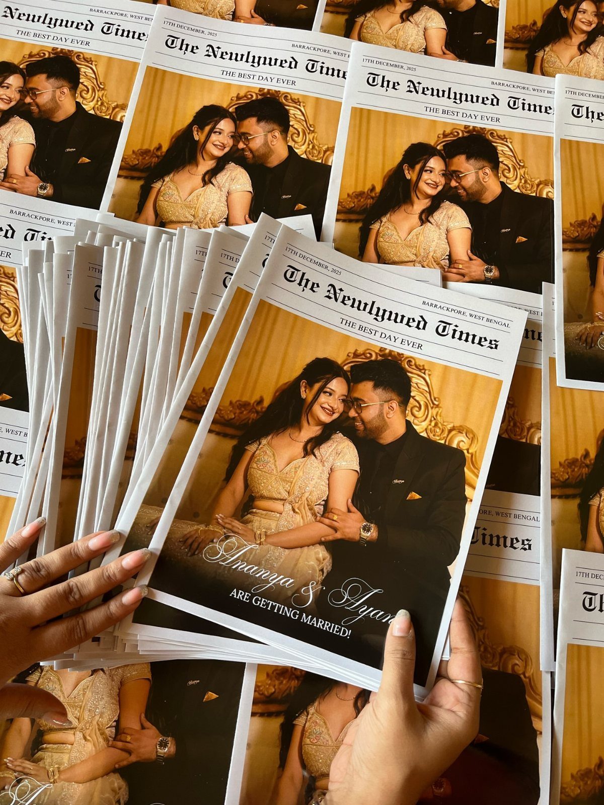 Wedding newspaper invitations featuring a couple, titled The Newlywed Times, held by hands.