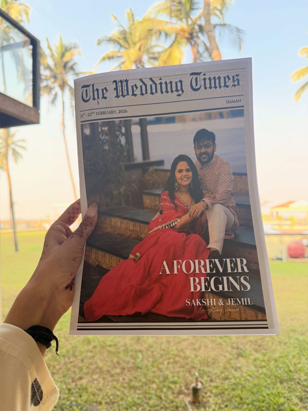 Wedding newspaper held up showing a couple in traditional Indian wedding attire.