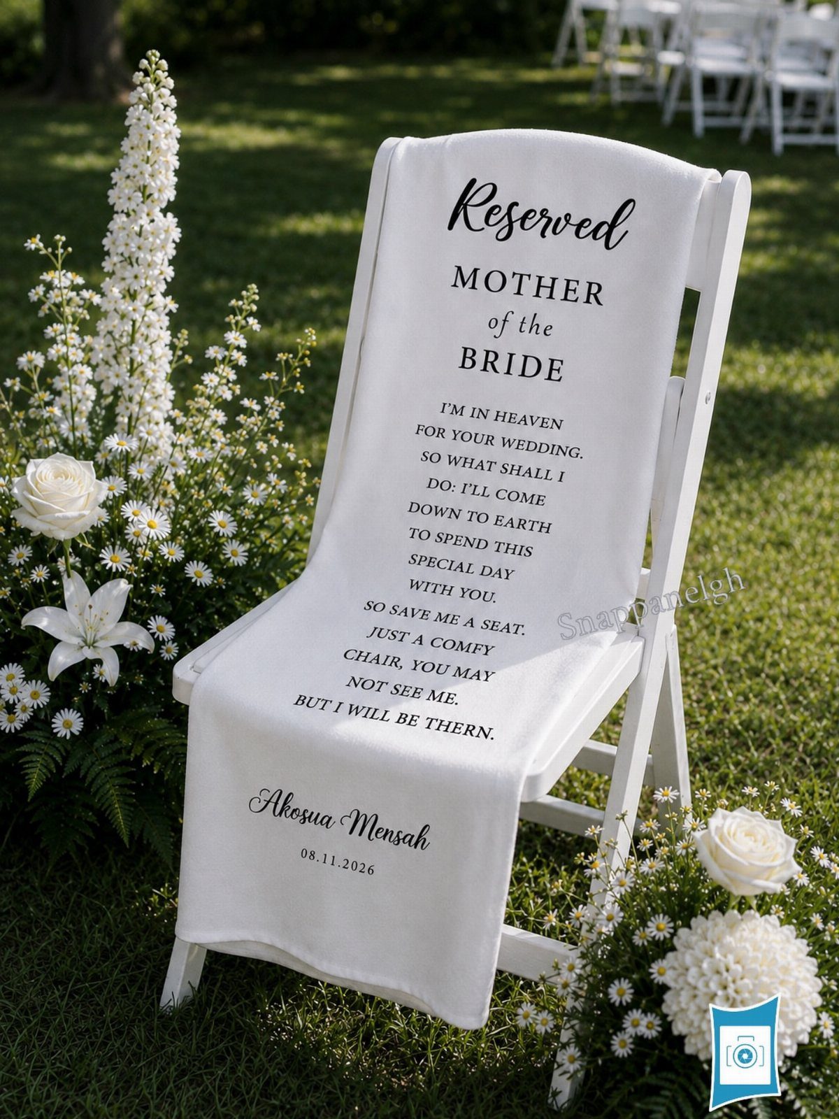 White chair draped in a memorial cloth with text, surrounded by white flowers.