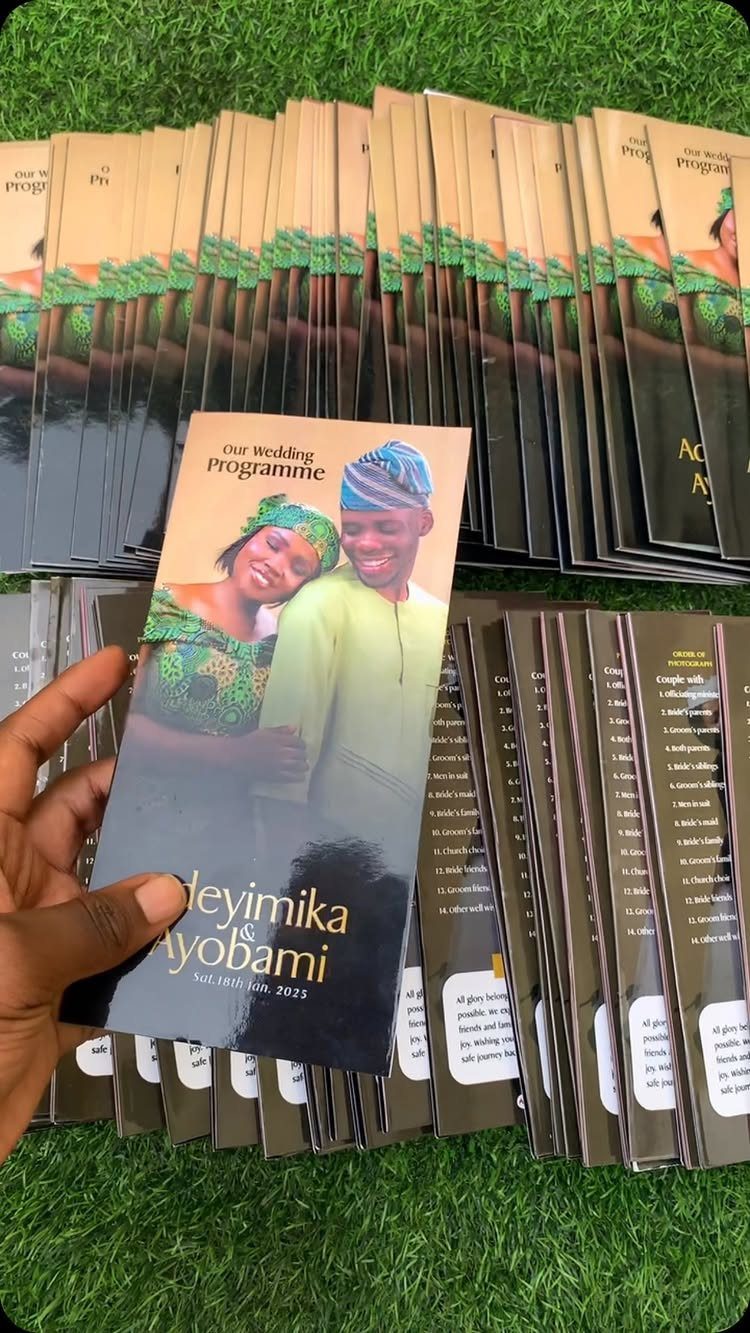 Wedding program featuring a couple in traditional dress held over a stack of programs.