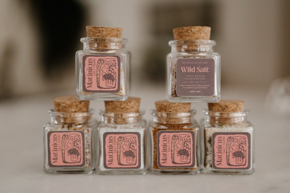 Small glass jars with cork lids filled with different colored sea salts.