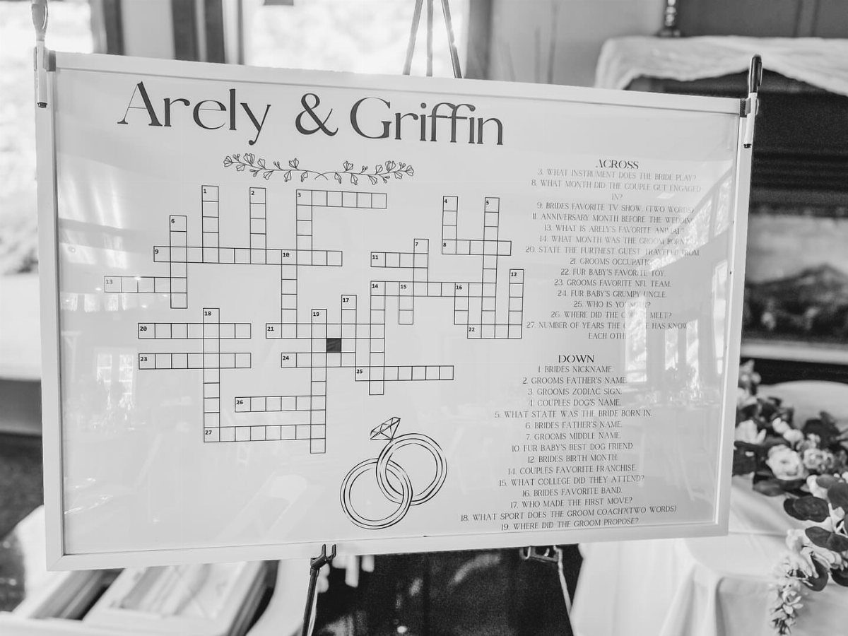 Framed wedding crossword puzzle for Arely and Griffin displayed on an easel.