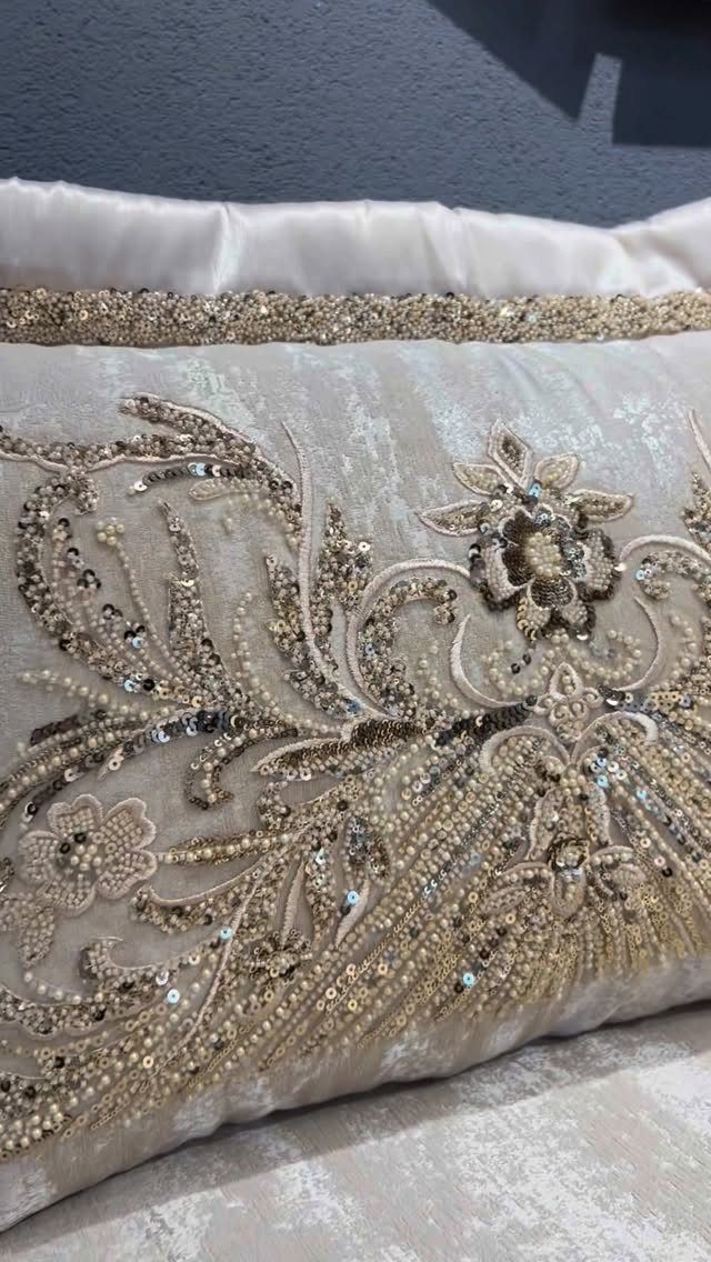 Champagne decorative pillow with intricate gold beadwork and floral sequin embroidery.