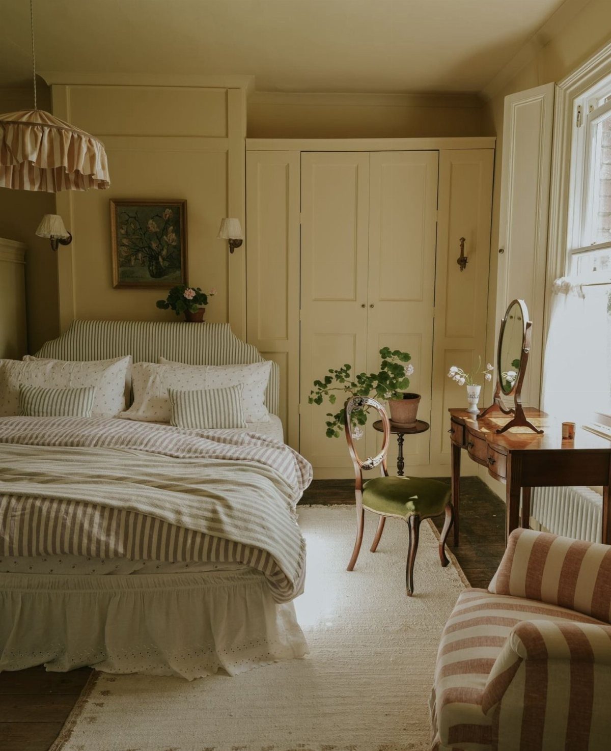 Bed with striped beige and white duvet covers in a neutral bedroom