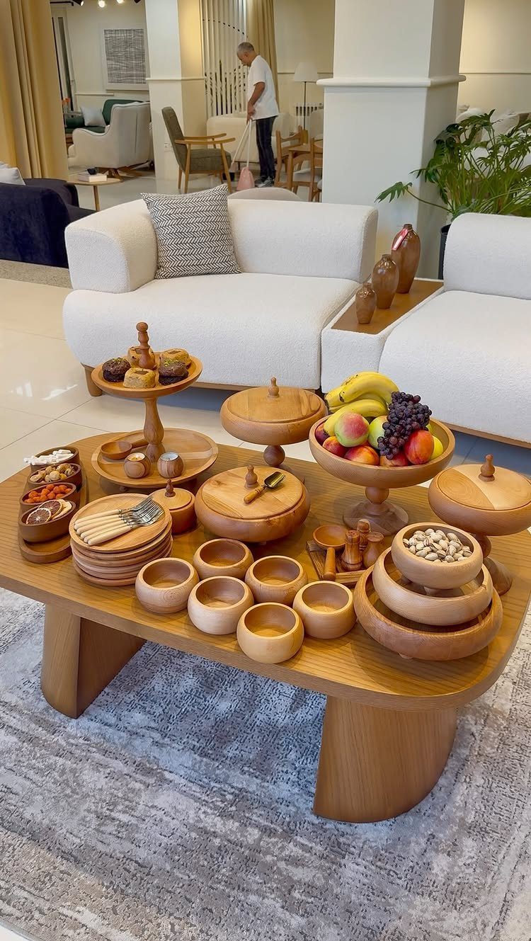 Wooden serving bowls and platters with fruit on a modern wooden coffee table