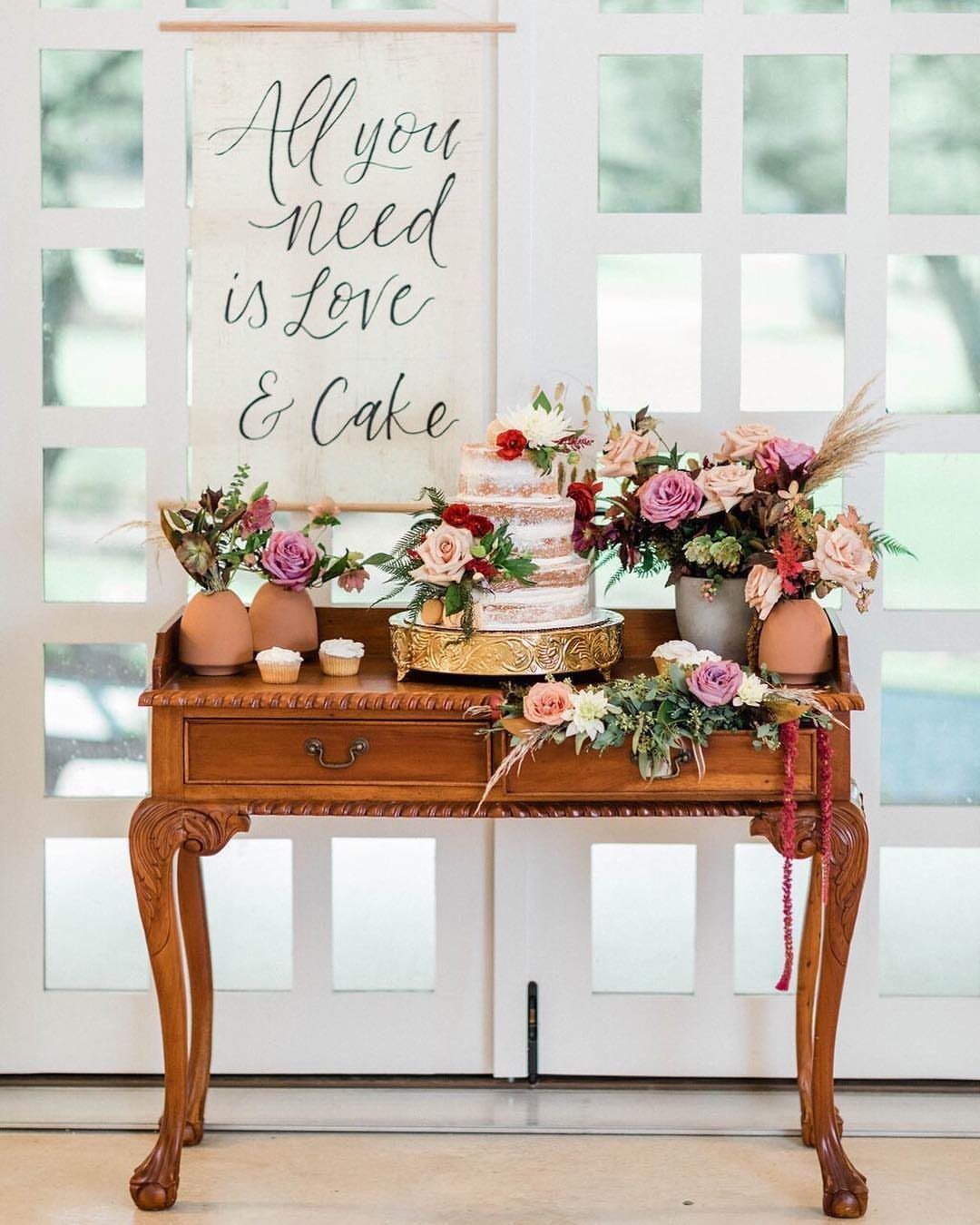 Dessert table with a tiered cake and a sign saying Love and Cake