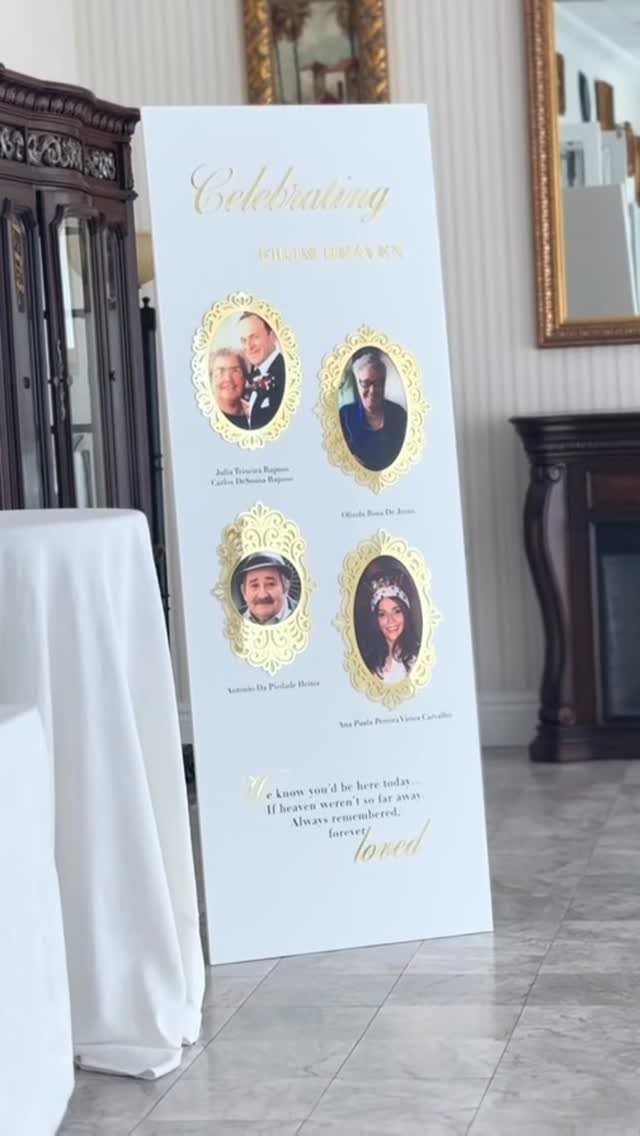 White memorial sign with gold frames and portraits of loved ones at a wedding